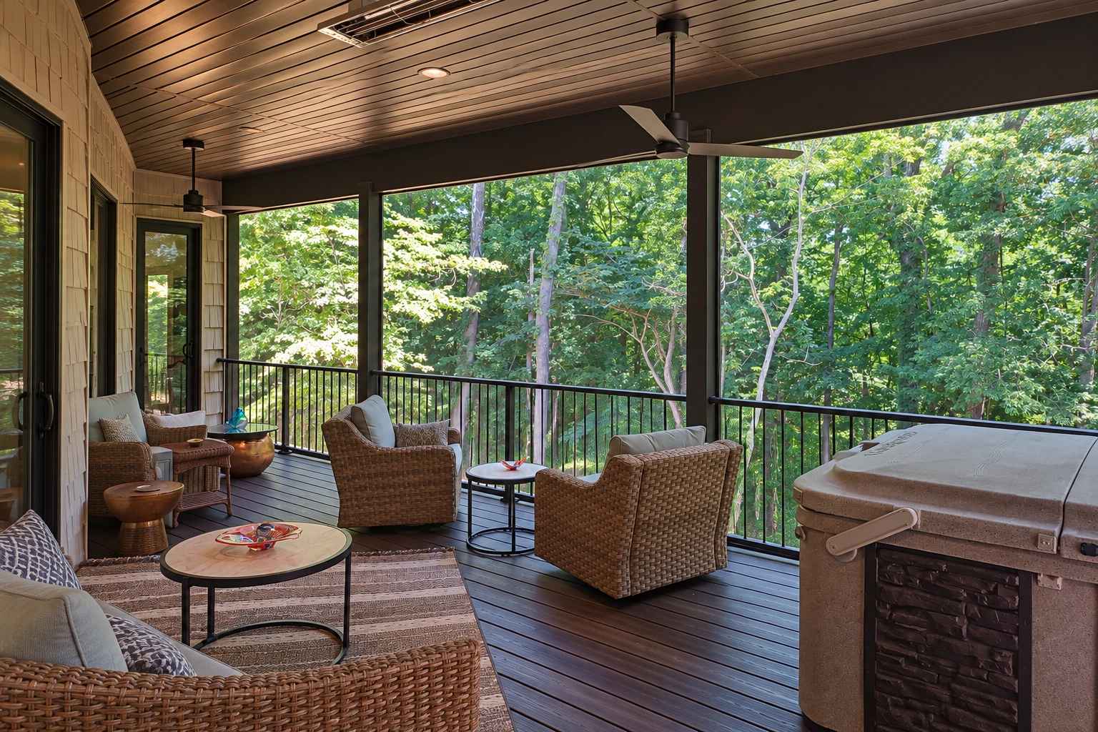 Covered deck with a dark paneled ceiling, wicker seating, black railing, and a hot tub.